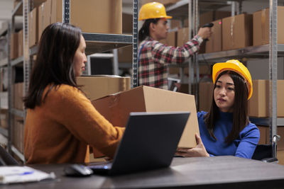 Young woman using laptop while sitting on table