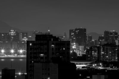 Illuminated buildings in city against sky at night