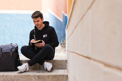 Male student making notes on street