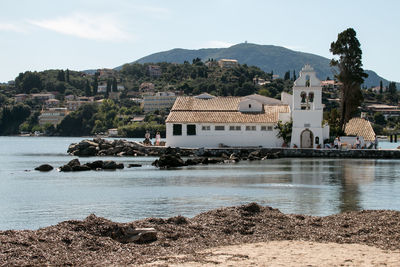 Buildings by sea against sky