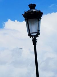 Low angle view of street light against cloudy sky