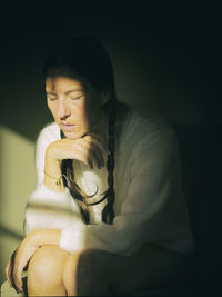 Portrait of young woman sitting on sofa at home