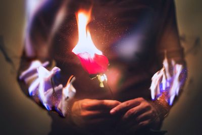 Close-up of hand holding candle