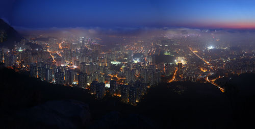 Illuminated cityscape against sky at night