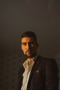 Portrait of young man standing against wall