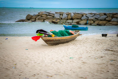 Lounge chairs on rocks by sea against sky