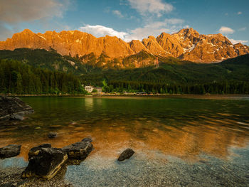 Scenic view of lake by mountains against sky