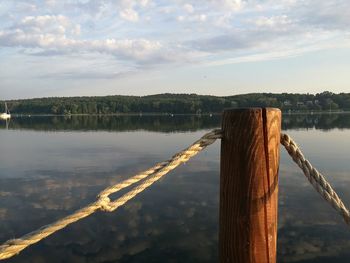 Pier on lake against cloudy sky