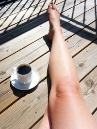 Low section of woman by black coffee cup