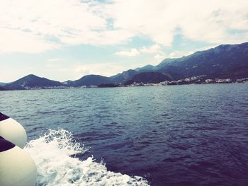 Scenic view of sea and mountains against sky