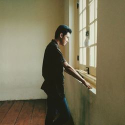 Young man standing in empty room