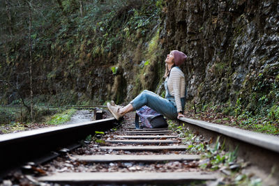 Woman sitting on railroad track