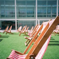 View of chairs on grass against building 