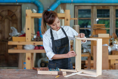 Portrait of beautiful asian woman carpenter dealing with handicraft