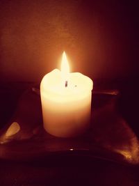 Close-up of lit candle in dark room