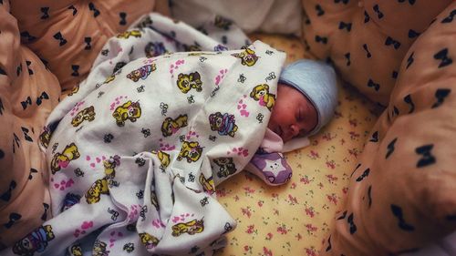 High angle view of baby sleeping on bed