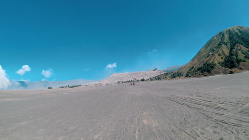 Scenic view of desert against blue sky