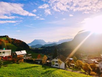 Scenic view of townscape by mountains against sky