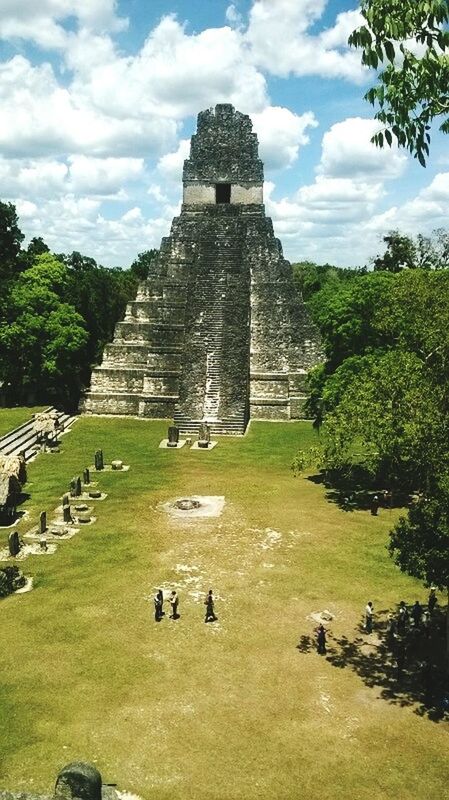 architecture, grass, built structure, sky, history, old ruin, famous place, ancient, travel destinations, the past, tourism, green color, cloud - sky, ancient civilization, tree, tourist, old, castle, cloud, day, landscape, lawn, outdoors, nature, grassy, tranquility