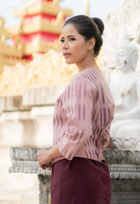 Young woman standing against temple