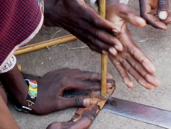 Cropped image of hands starting fire with wood