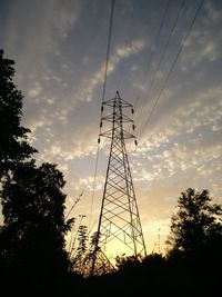 Low angle view of silhouette electricity pylon against sky during sunset