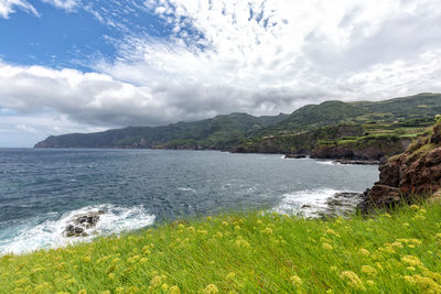 Scenic view of sea and mountains against sky