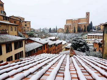 Snow covered city against clear sky