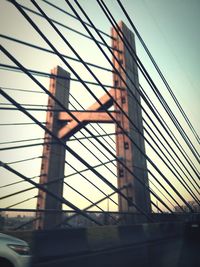 Low angle view of suspension bridge against sky