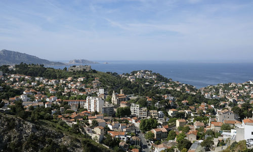 High angle view of townscape by sea against sky