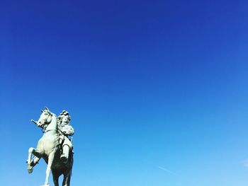 Low angle view of statue against clear blue sky