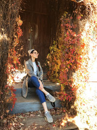 Young woman sitting on tree trunk