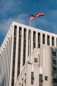 Low angle view of flag against buildings in city