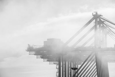 Low angle view of built structure amidst fog against sky