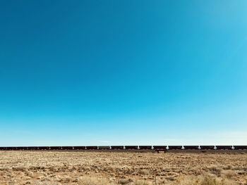 Scenic view of field against clear blue sky
