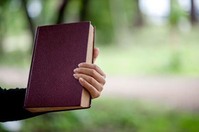 Cropped hand of woman holding book