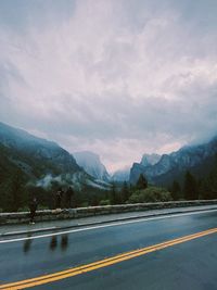 Road leading to mountains against sky