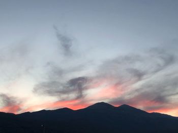 Scenic view of silhouette mountains against sky at sunset