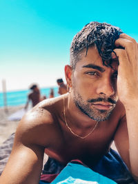 Portrait of mature man at beach against clear sky