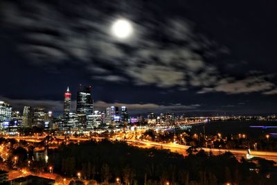 Illuminated buildings in city against sky at night