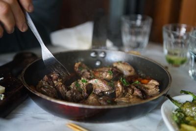 Cropped hand with food at table