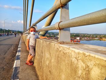 A small child is looking at the mahakam river from the crown bridge 2 in the afternoon