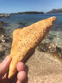 Close-up of hand holding ice cream cone at beach