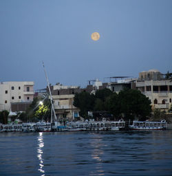 Scenic view of river by buildings against sky