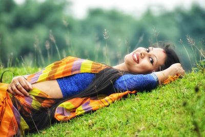 Portrait of young woman lying on grass