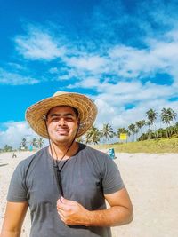 Portrait of man wearing hat standing on beach