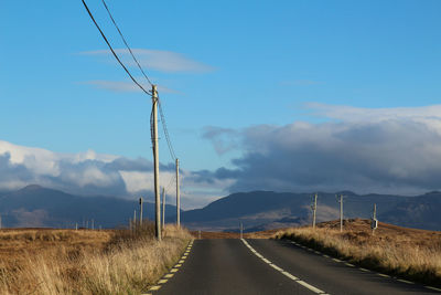 Country road against sky