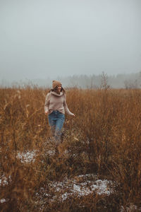 Woman standing on field against sky