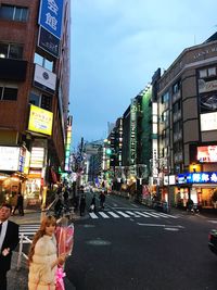 Crowd on illuminated city against sky at night