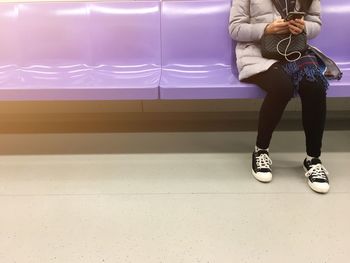 Low section of woman standing against wall